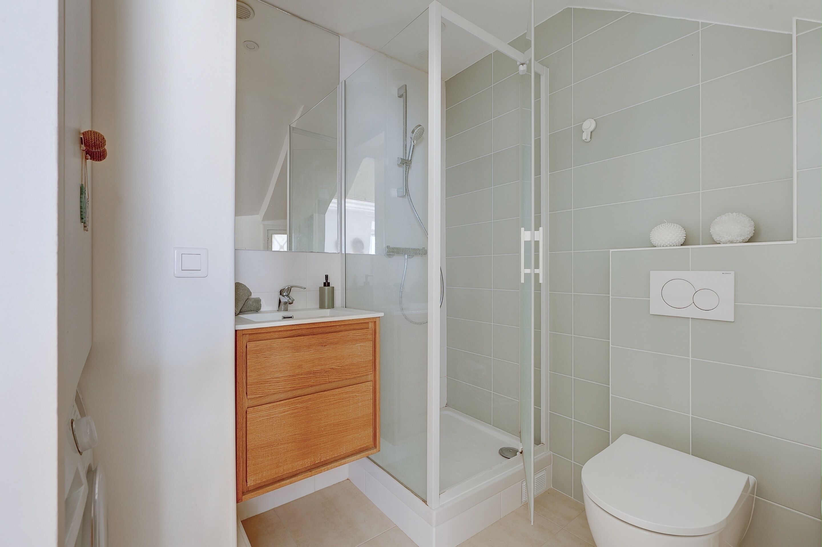 A modern bathroom with a glass-enclosed shower, a wooden vanity, and a toilet.