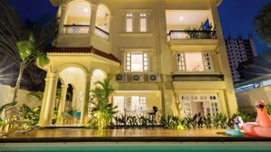 En byggnad med flera våningar, med en pool i förgrunden.