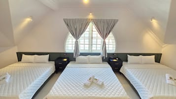A hotel room with two beds, a large window with curtains, and a ceiling light.