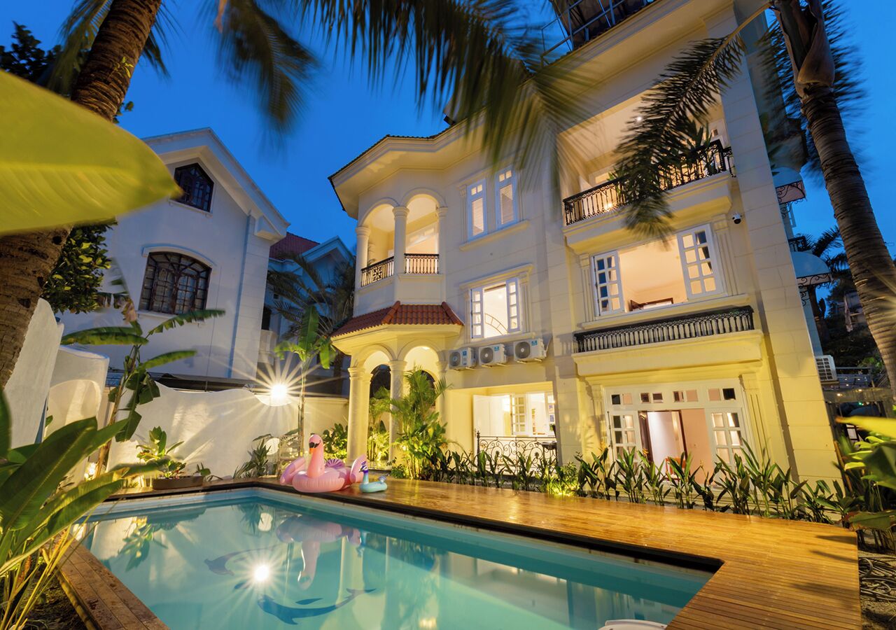 A large, multi-story building with a pool and outdoor seating area.