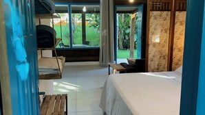 Een slaapkamer met een bed, een bankje, een tafel en uitzicht op de omgeving.
