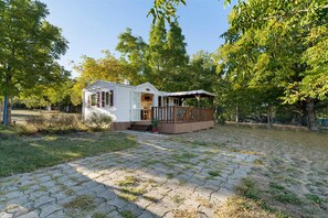 Une petite cabane d’un seul étage, dotée d’un porche et d’une cour clôturée.