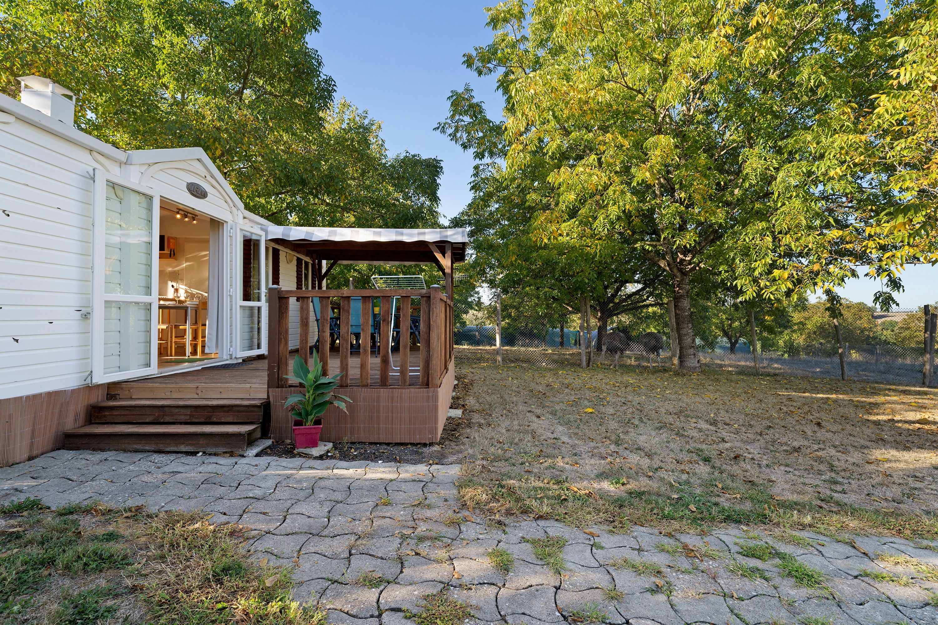 Een gelijkvloers huis met een overdekte veranda en een kleine tuin.