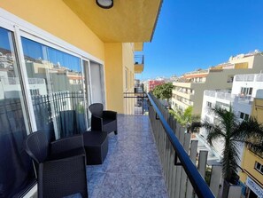Ein Balkon mit Sitzgelegenheit und Blick auf die Stadt, ausgestattet mit einem Geländer.