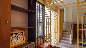 A staircase with a yellow railing, a wooden door frame, and a metal gate. - Vel Ohm Homestay (Puducherry)
