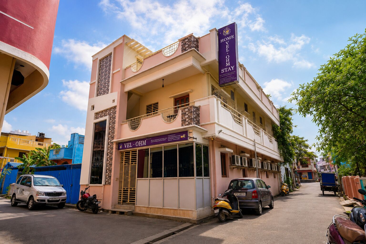 A two-story building with a sign for 'Home Vel-Ohm Stay' and a smaller sign for 'Vel-Ohm'.