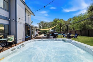 A backyard with a hot tub, outdoor seating, and a barbecue area. - Pool Haven | Hot Tub Fire Pit Game Room Sleeps 18 (San Antonio)