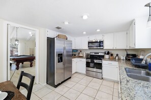 A modern kitchen with stainless steel appliances, a built-in oven, and a microwave. - Pool Haven | Hot Tub Fire Pit Game Room Sleeps 18 (San Antonio)