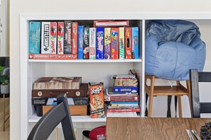 Ein Bücherregal voller verschiedener Brettspiele und ein blauer Sitzsack.