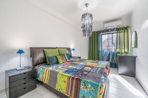 Ein Schlafzimmer mit einem Bett, einem Schminktisch, einer Lampe und einer Pendelleuchte.