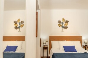 Ein Hotelzimmer mit Bett, Nachttisch, Lampe und Wandbild.