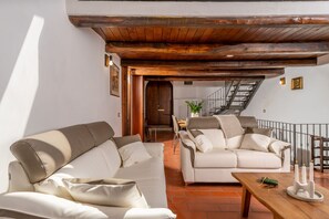 A spacious living area with two sofas, a wooden coffee table, and a staircase leading to an upper floor. - Views from Trevi - apartment in Trevi (Trevi)