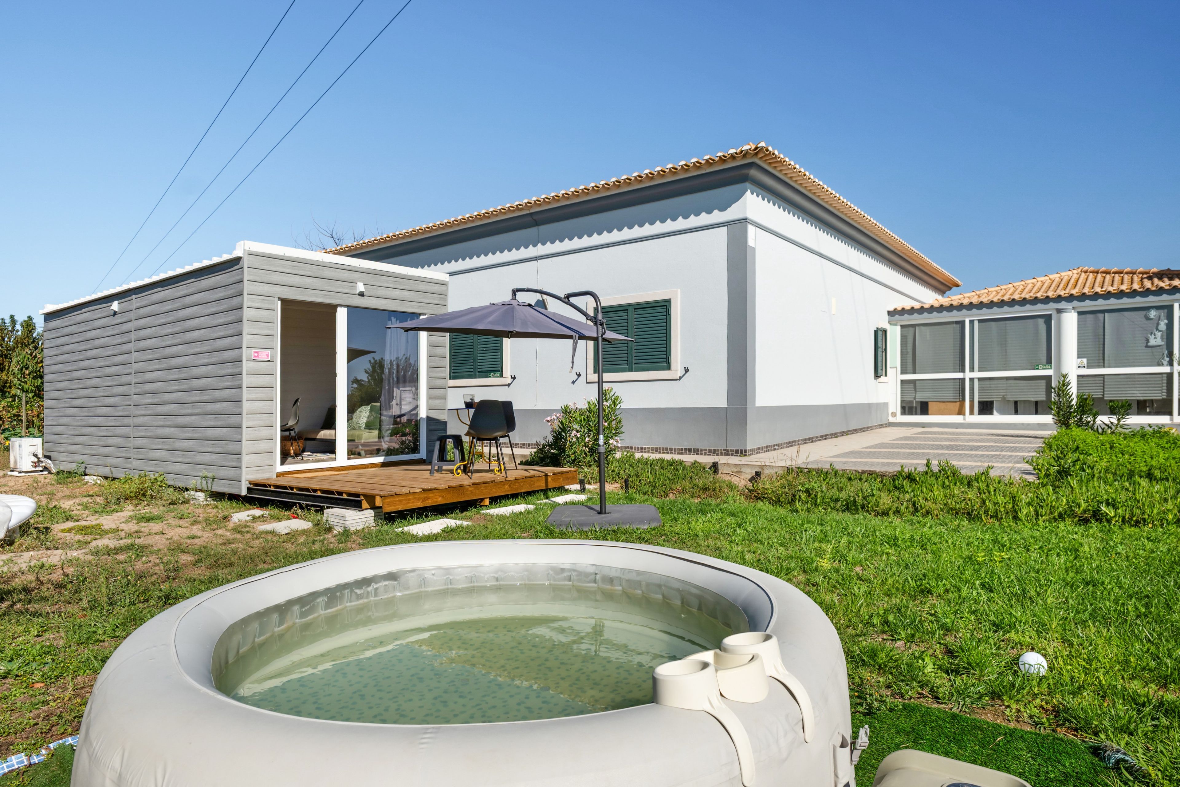 Une maison moderne dotée d’une terrasse, d’un jacuzzi et d’un espace patio.