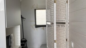 A room with a bed, a window, a radiator, and a wall-mounted rack. - Tiny House with Shared Pool, Wi-Fi, and Air Conditioning (Palmela)
