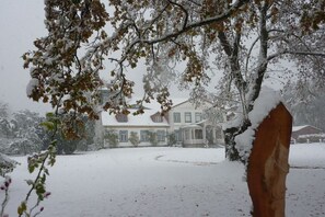 A snow-covered landscape with a large house and a tree in the foreground. - Holiday apartment with 2 bedrooms (Groß Zecher)