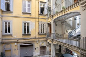 A multi-story building with balconies, a staircase, and a garage door. - Double Room with Wi-Fi and Air Conditioning (Napoli)