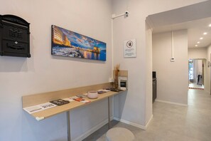 A reception area with a counter displaying brochures and a painting of a cityscape. - Double Room with Wi-Fi and Air Conditioning (Napoli)