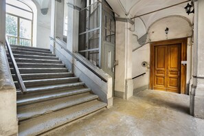 A staircase leading to a wooden door with a metal gate above it. - Double Room with Wi-Fi and Air Conditioning (Napoli)