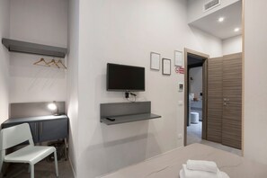 A modern hotel room with a desk, chair, TV, and a wardrobe. - Double Room with Wi-Fi and Air Conditioning (Napoli)