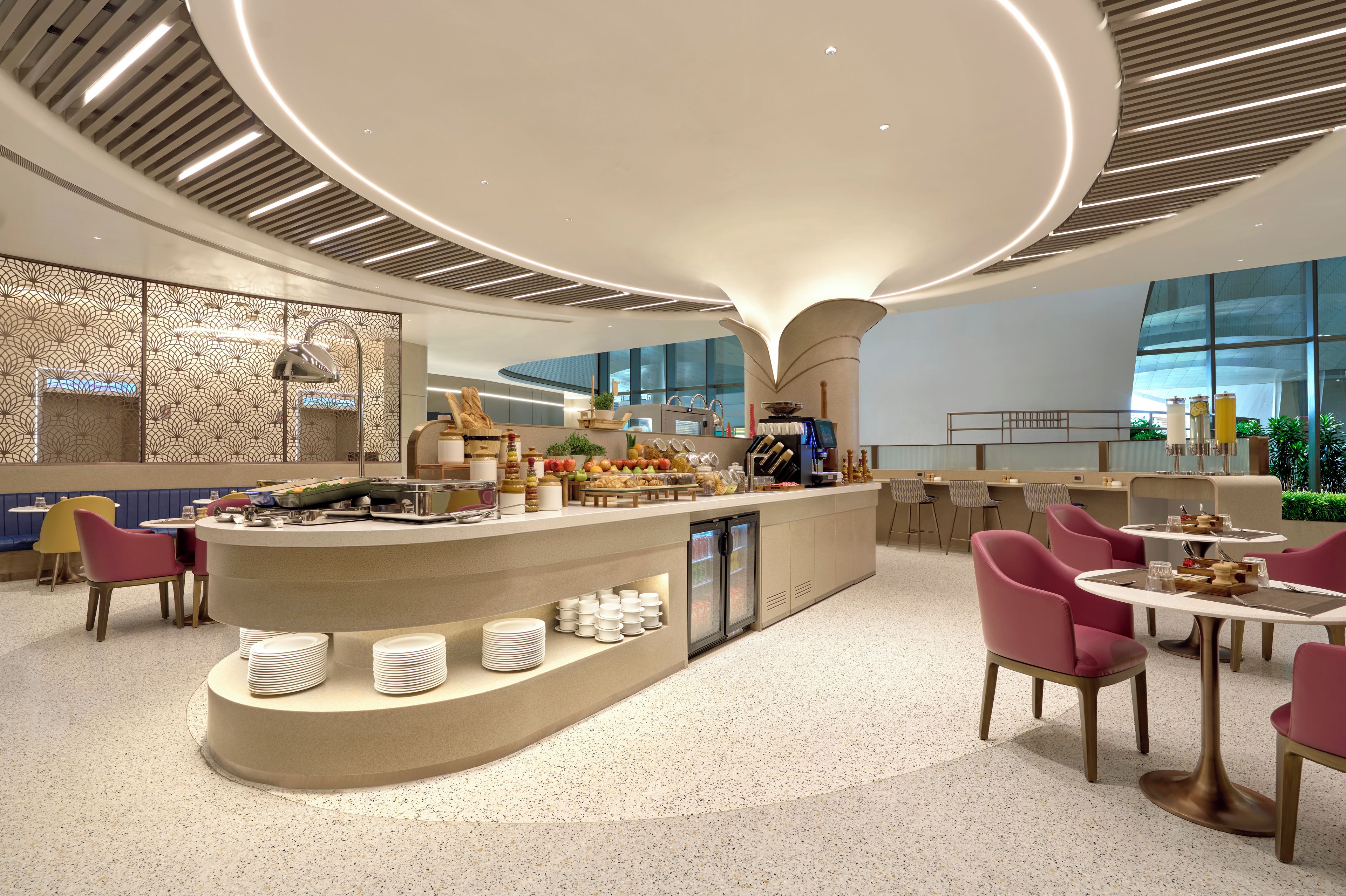 A modern interior with a central bar area, seating arrangements, and a decorative ceiling.
