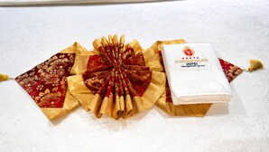 Toalhas dobradas e um folheto de hotel dobrado sobre uma superfície estampada.