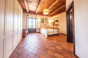 A bedroom with a bed, a wardrobe, a desk, and a chair.
