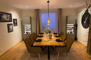 A dining area with a wooden table set for six, surrounded by chairs, with a pendant light above and a plant on the table. - HarzVilla Bad Sachsa. (Bad Sachsa)