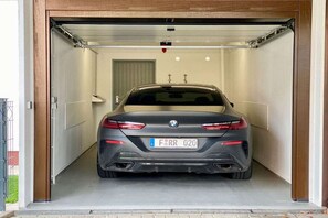 A car parked inside a garage with a door. - HarzVilla Bad Sachsa. (Bad Sachsa)
