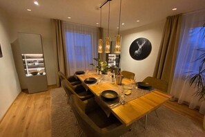 A modern dining area with a wooden table, black chairs, and pendant lighting. - HarzVilla Bad Sachsa. (Bad Sachsa)