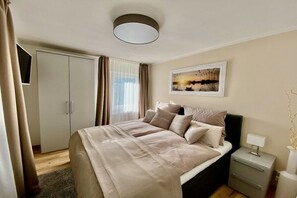 A bedroom with a bed, nightstand, and a painting on the wall. - HarzVilla Bad Sachsa. (Bad Sachsa)