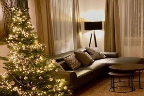 A living room with a Christmas tree, a sofa, a coffee table, and a floor lamp. - HarzVilla Bad Sachsa. (Bad Sachsa)
