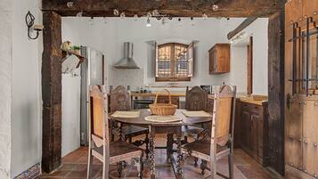 Un comedor rústico con una mesa de madera, sillas y un ventanal grande.