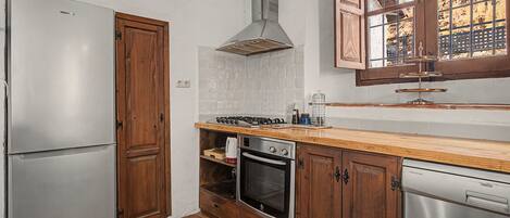 A compact kitchen with a refrigerator, stove, oven, and dishwasher.