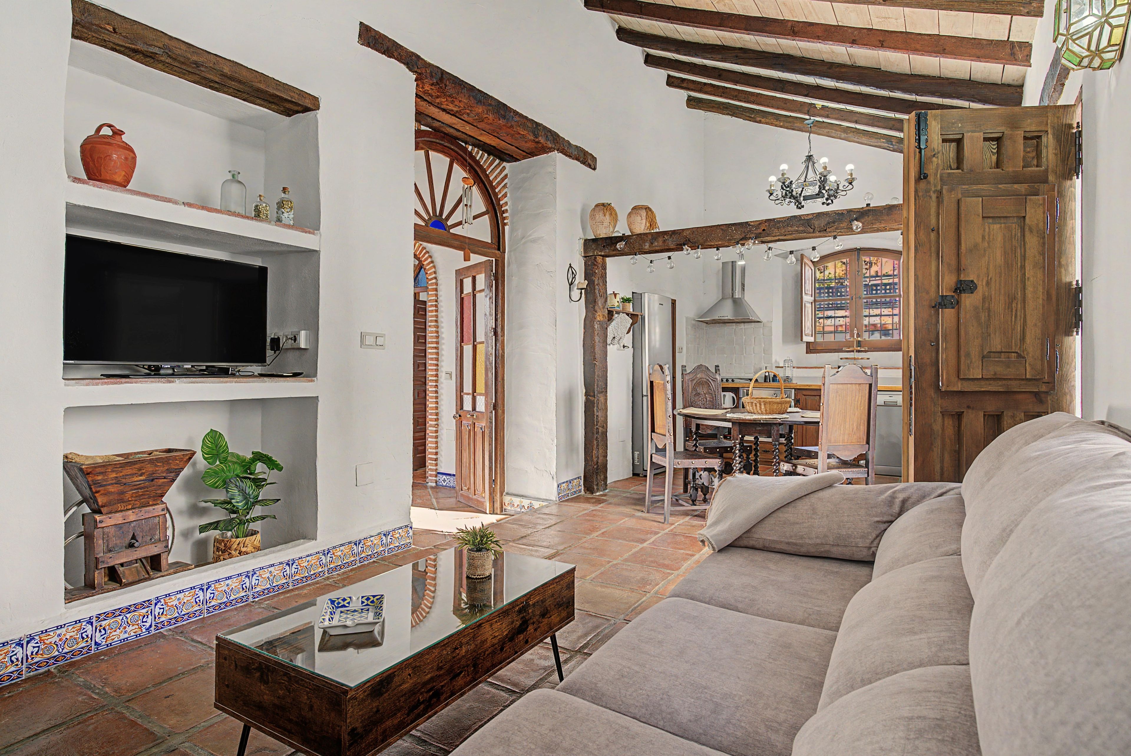 Un salón con televisor, sofá y una mesa de centro.