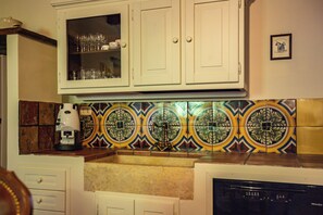 A kitchen with white cabinets, a coffee maker, and a dishwasher.