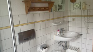 A bathroom with a toilet, sink, and shower area. - Cozy Holiday Apartment with Garden in Solzow Farmhouse (Südmüritz)