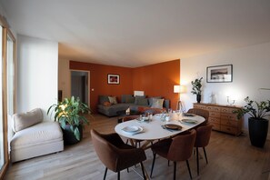 Una sala de estar moderna con comedor, un conjunto de sofás y una mesa de centro.