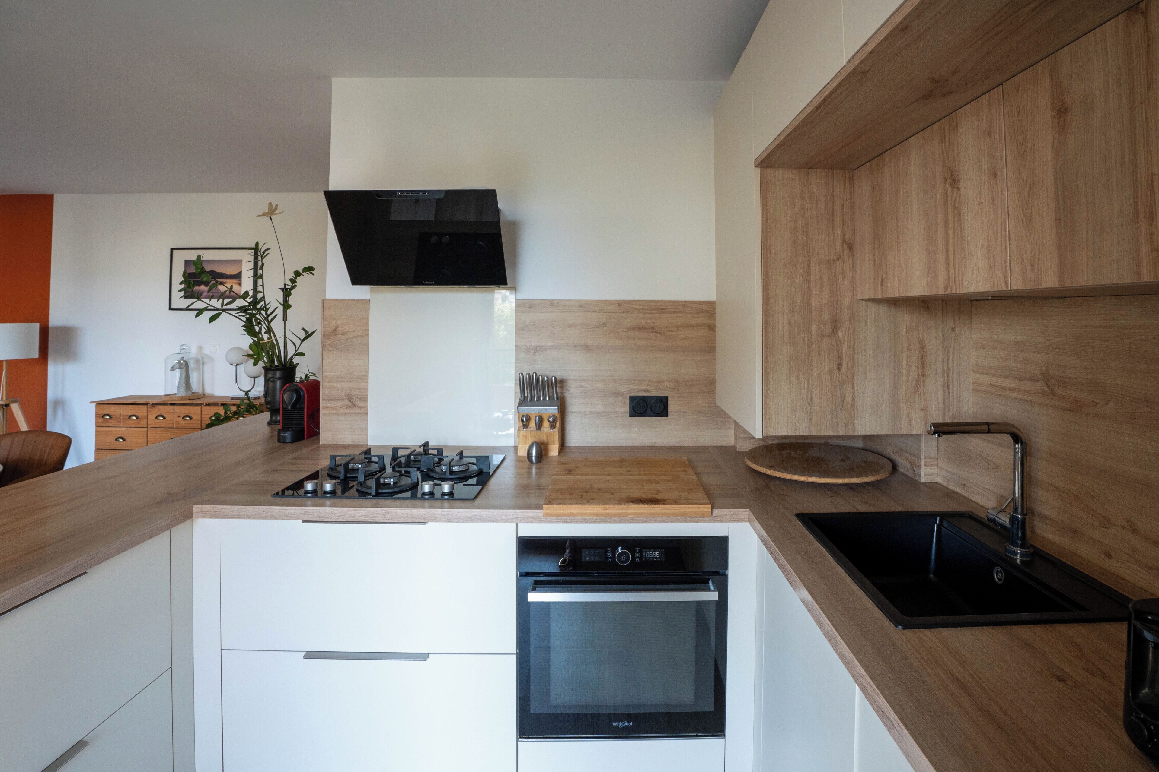 Een moderne keuken met een inbouwgasfornuis, oven en vaatwasser.