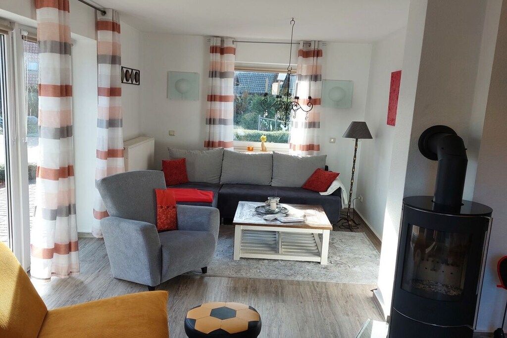 Ein Wohnzimmer mit Sofa, Sesseln, Couchtisch und Kamin.