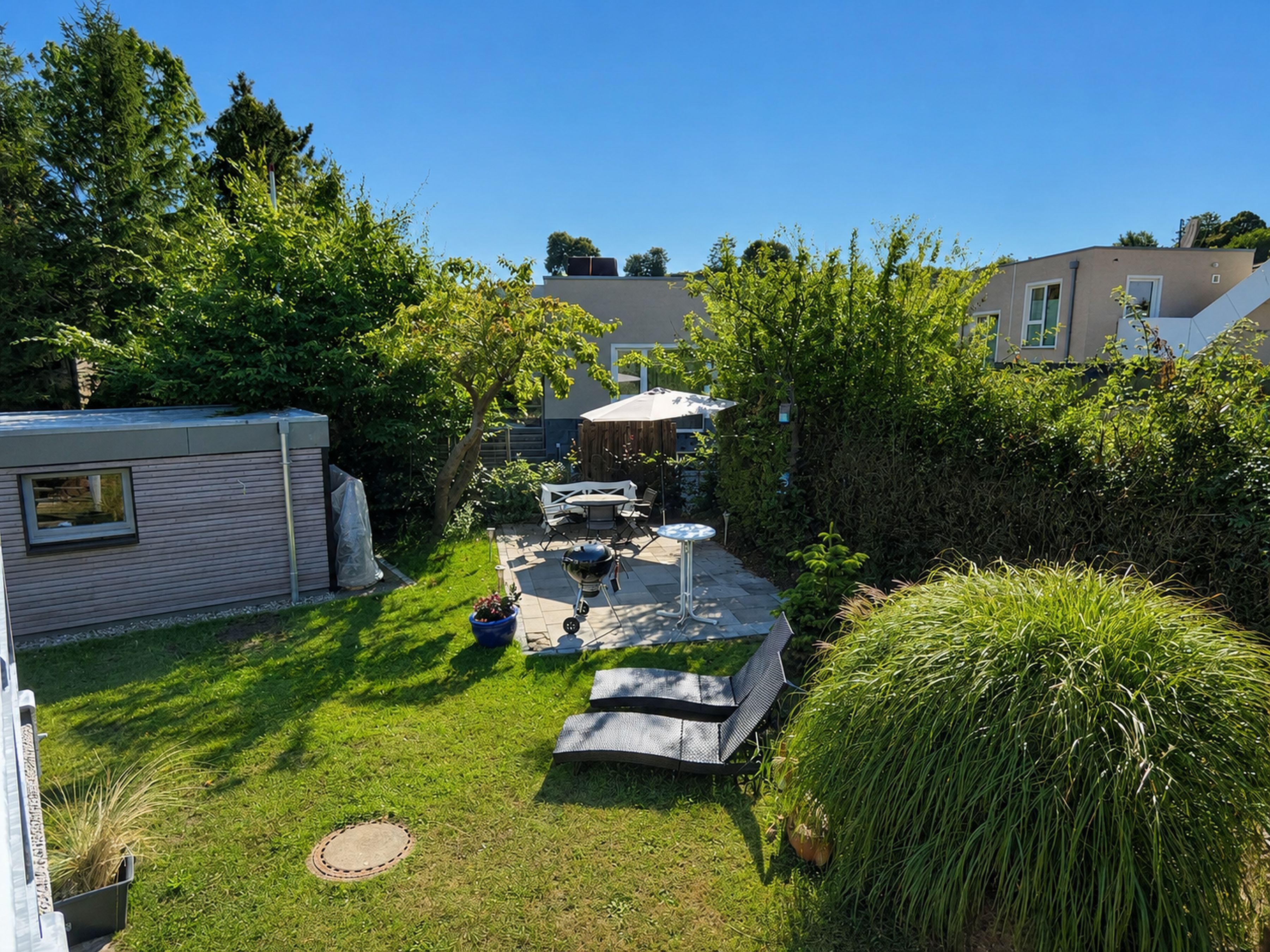 A backyard with a barbecue area, outdoor furniture, and a covered patio.