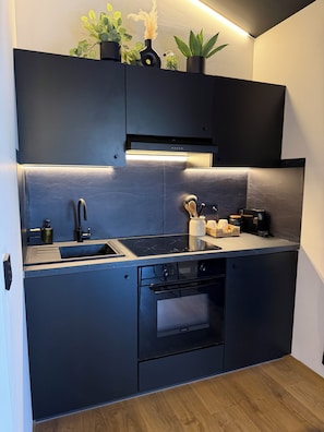 Cozinha moderna com forno embutido, pia e bancada.