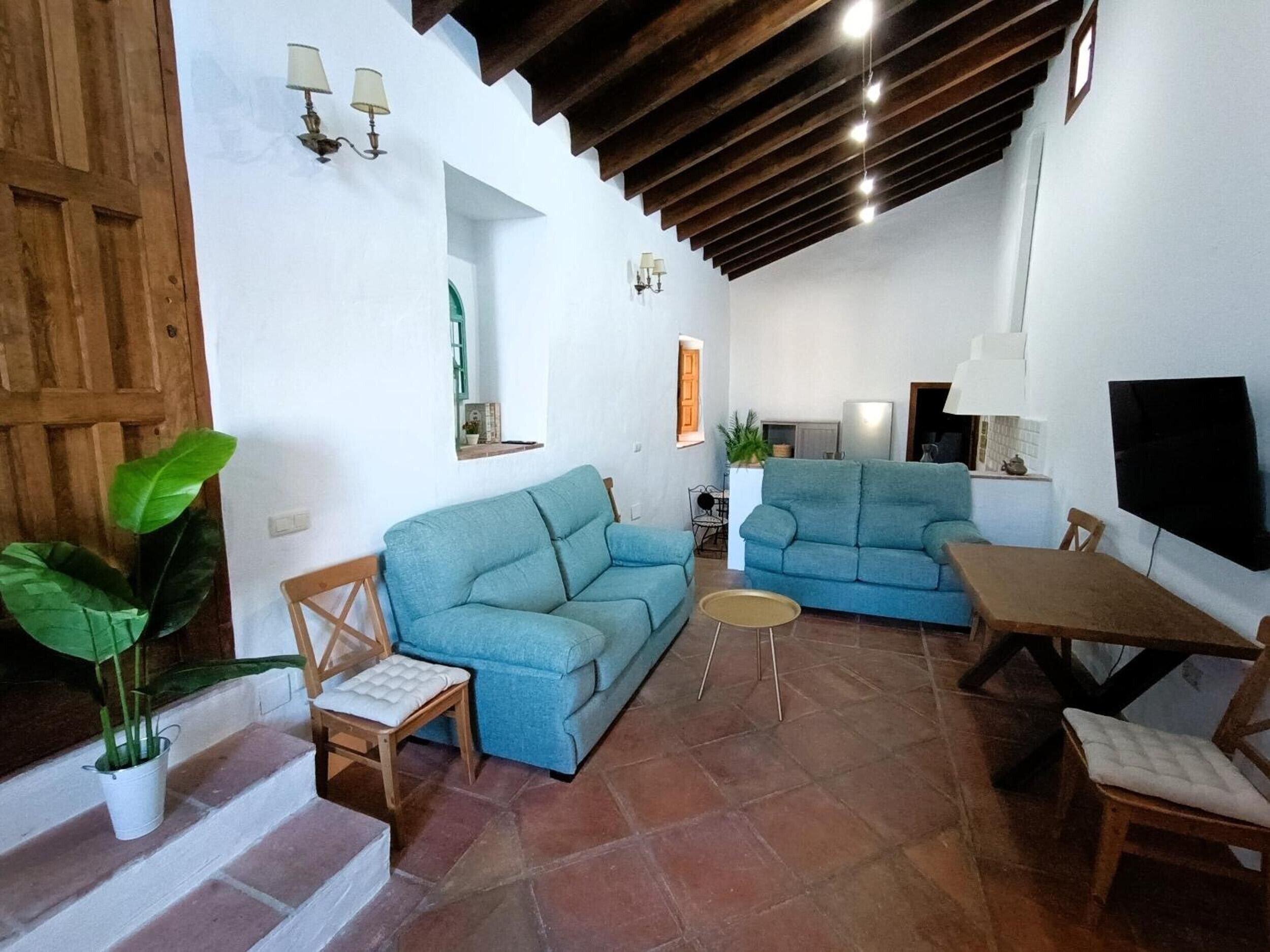 Una sala de estar con dos sofás, una mesa de madera y un televisor.