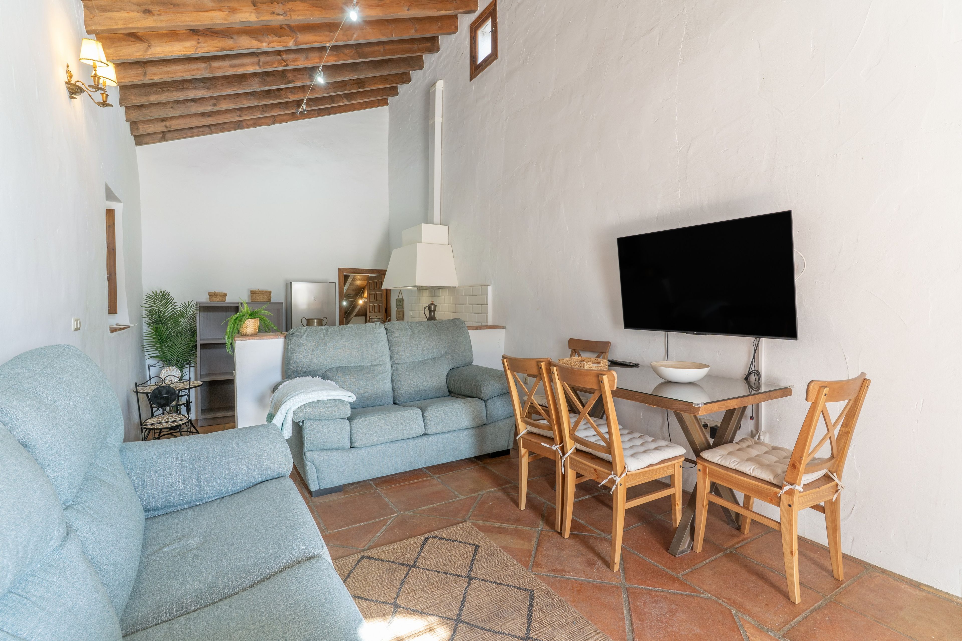 A living room with a sofa, chairs, a TV, and a dining table.