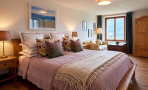 A bedroom with a large bed, multiple pillows, a nightstand, a bedside table, a window with curtains, and a view of the outdoors. - Sompriezzo: Lake View (Tremosine)