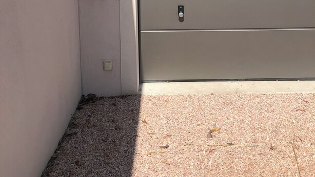 Une porte de garage avec un coffre de sécurité et une boîte aux lettres fixée au mur.