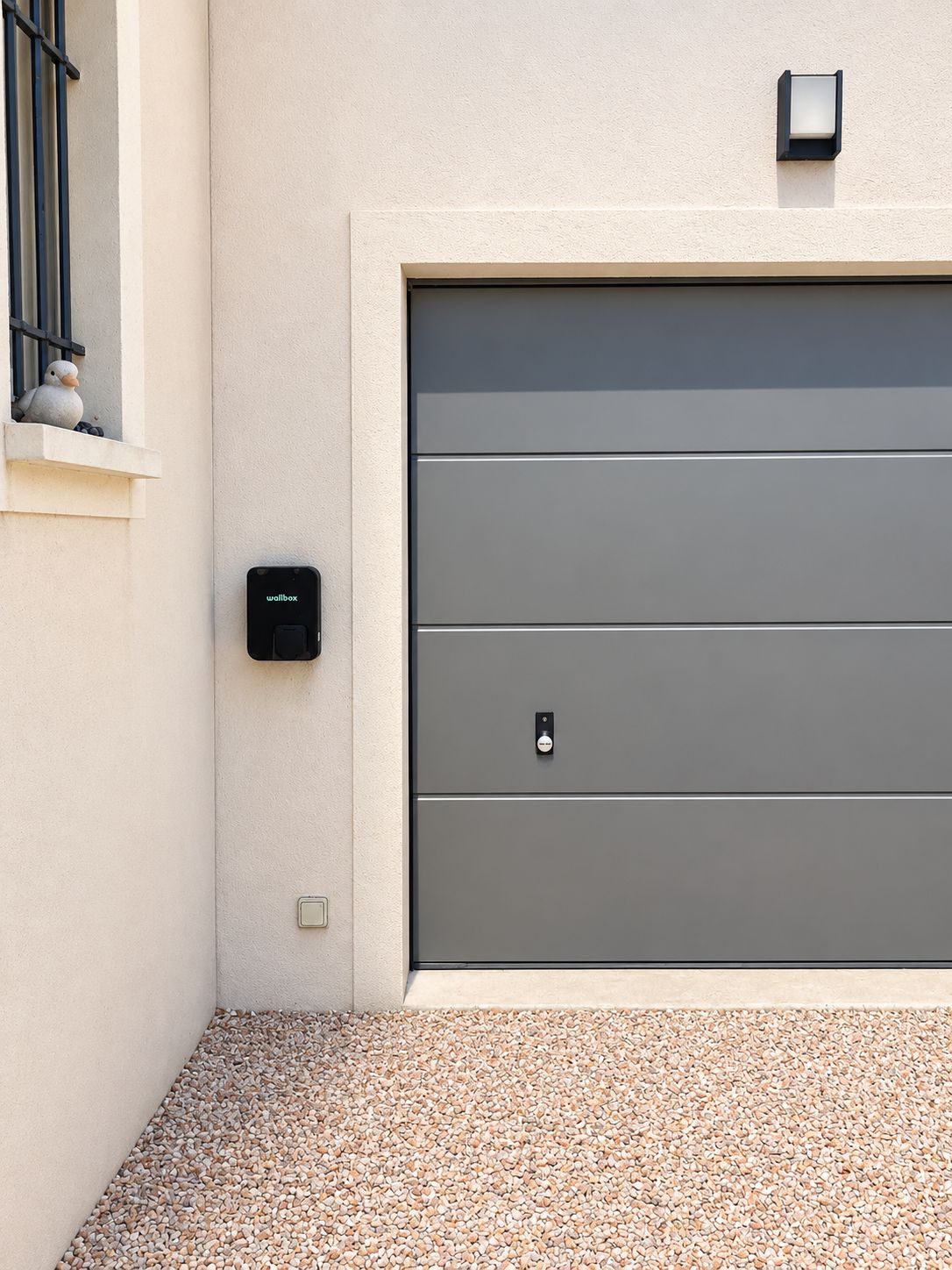 A modern garage door with a wall-mounted intercom and a mailbox.