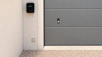 A modern garage door with a wall-mounted intercom and a mailbox.
