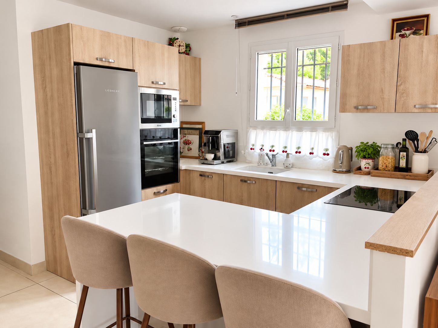 Une cuisine moderne équipée d’un réfrigérateur, d’un four et d’un grand îlot central avec des chaises.