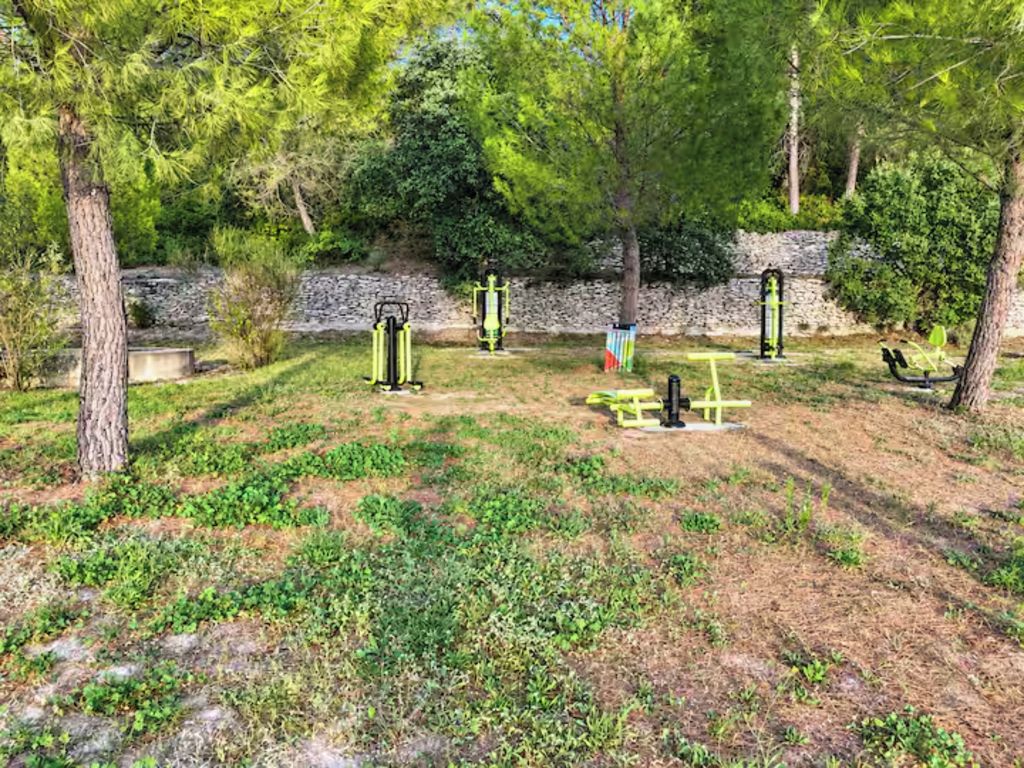 An outdoor exercise area with fitness equipment and a picnic table.