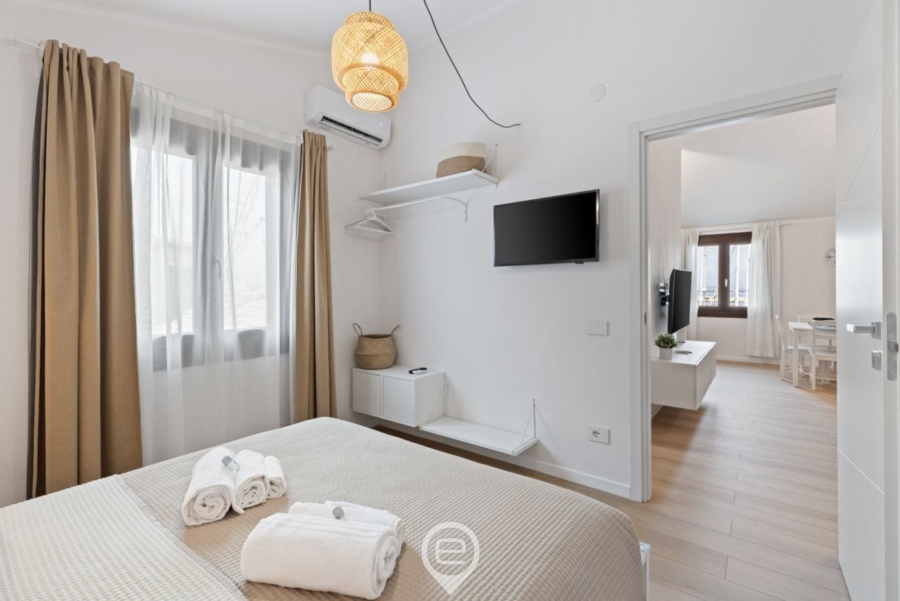 A hotel room with a bed, a television, a desk, and a chair.